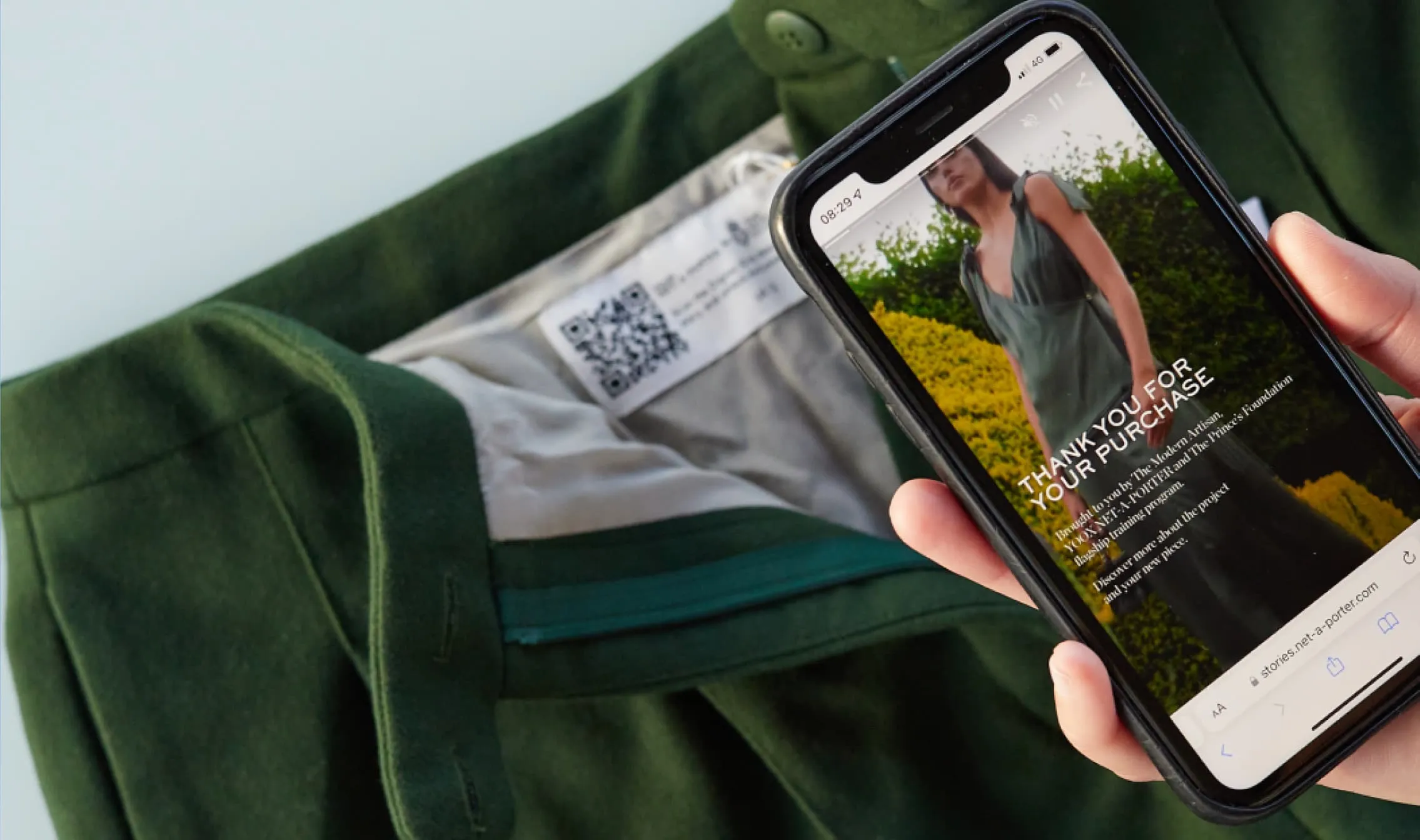 A smartphone scanning a Digital ID in the form of a QR code stitched into a pair of Modern Artisan trousers by YOOX Net-a-Porter